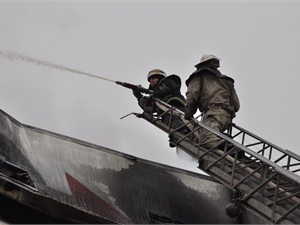 Бойцы спускают с верхних и нижних этажей штурмовые лестницы, по которым и добираются до очага по наружным стенам. Фото Kp.ua