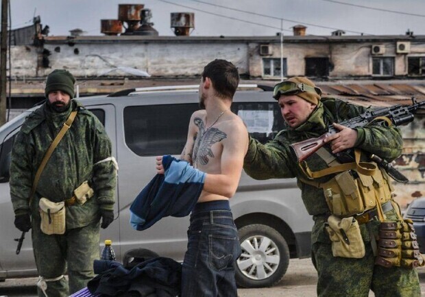 На блокпості у Василівці окупанти знімають в людей відбитки пальців. 