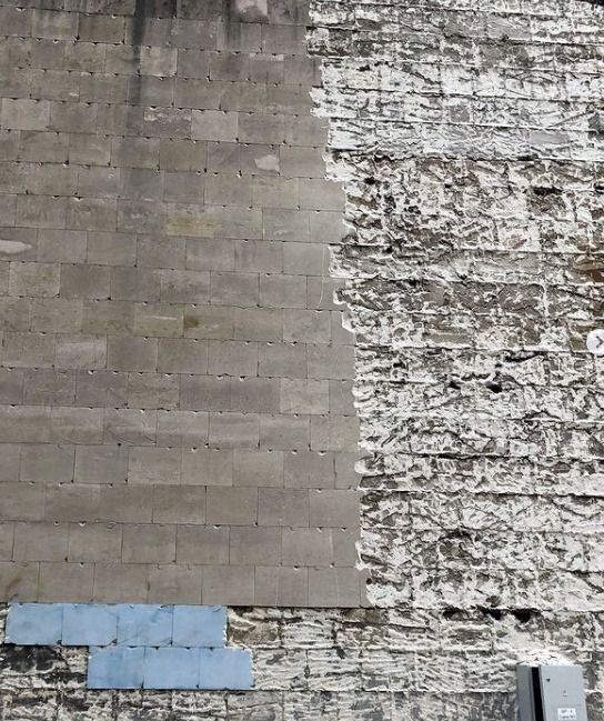 Строители оббивают старую фасадочную плитку. Фото: Дмитрий Соловьев