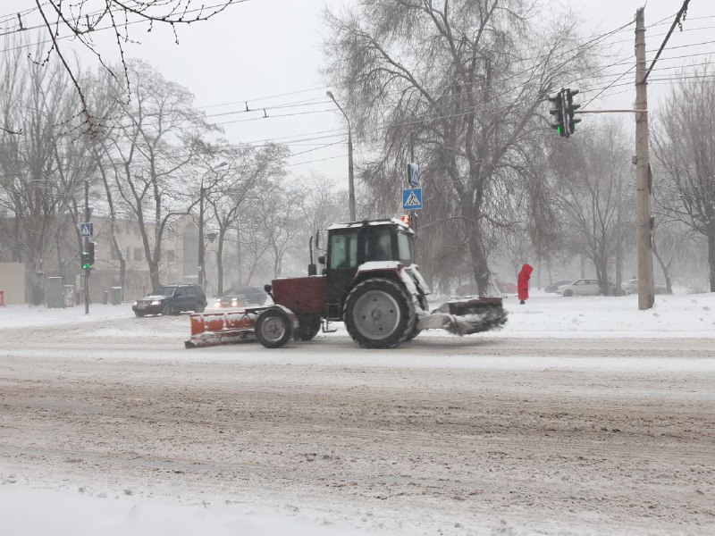 Коммунальщики расчищают заснеженные дороги Запорожья.