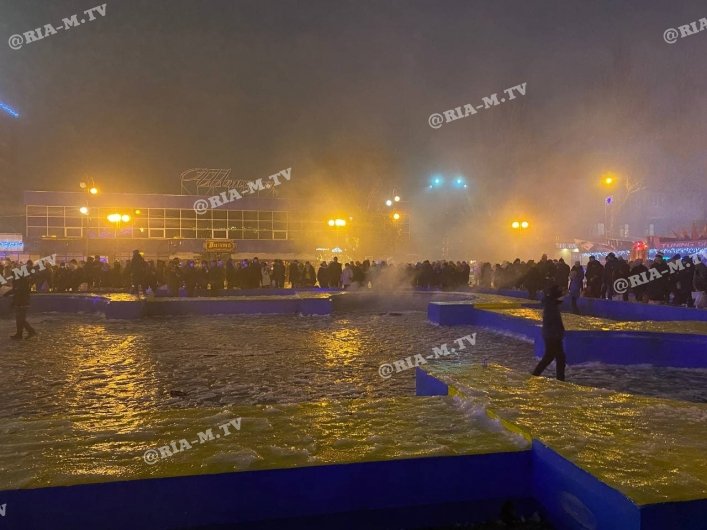 Люди отмечают Новый год на площади Победы.